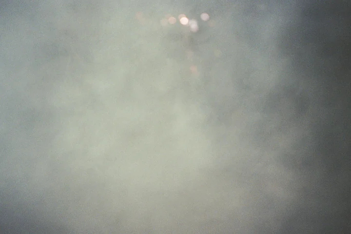 Vage lichtpunten achter een sluier van mist
