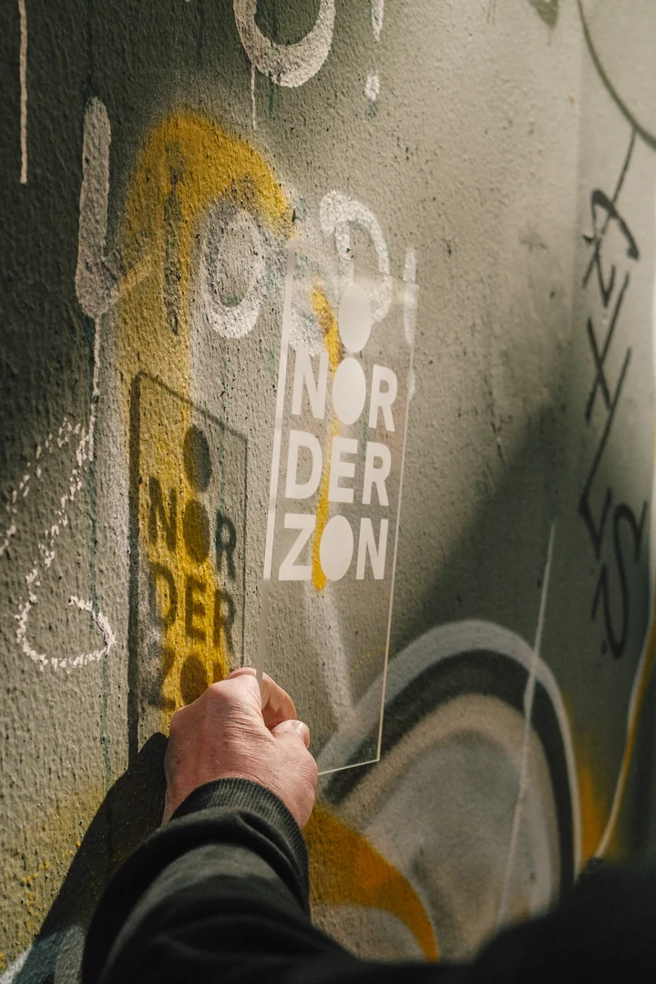 Hand en Noorderzon-letters weerspiegeld in glas