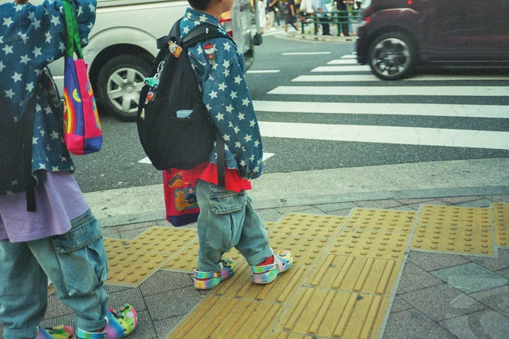 Twee kinderen in sterrenjassen bij een oversteekplaats in Japan
