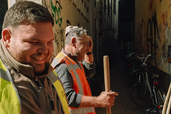 Twee lachende vakmensen tijdens hun werk in de stad