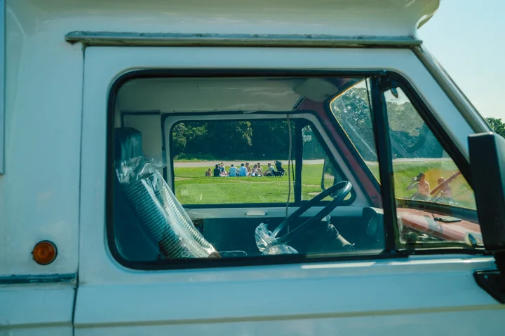 Bezoekers in het Stadspark gezien door het raam van een foodtruck